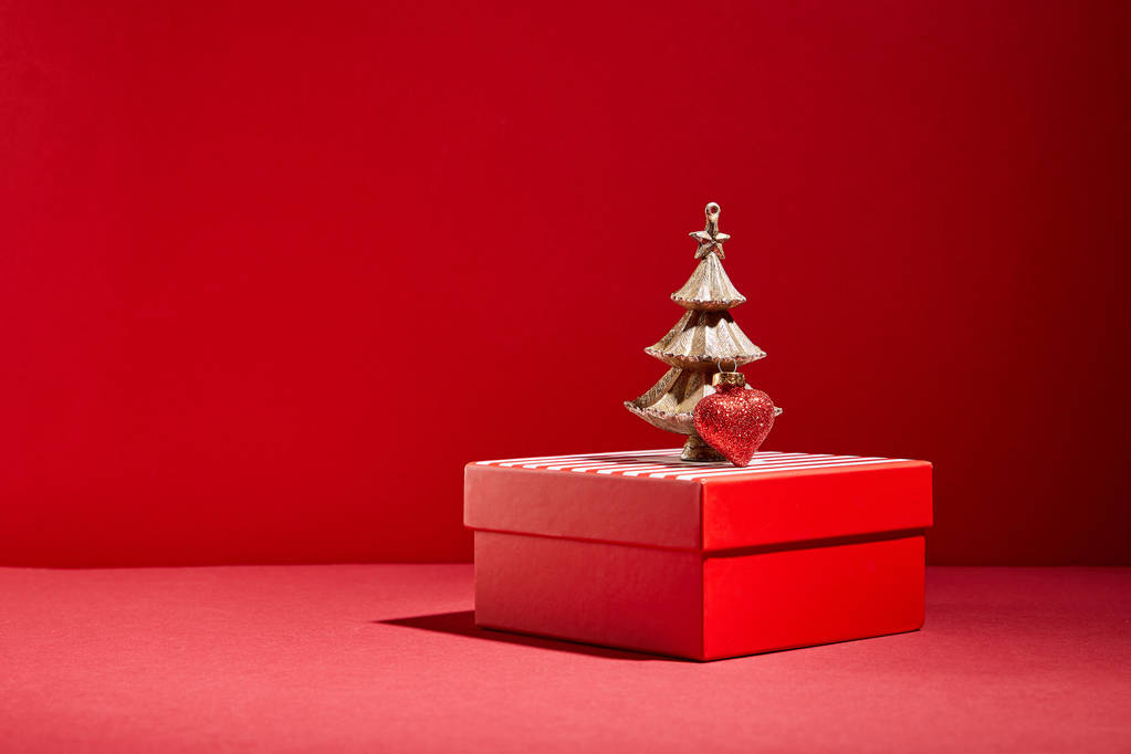 赤いギフトボックスと赤い背景に泡と装飾的な黄金のクリスマスツリー - 写真・画像