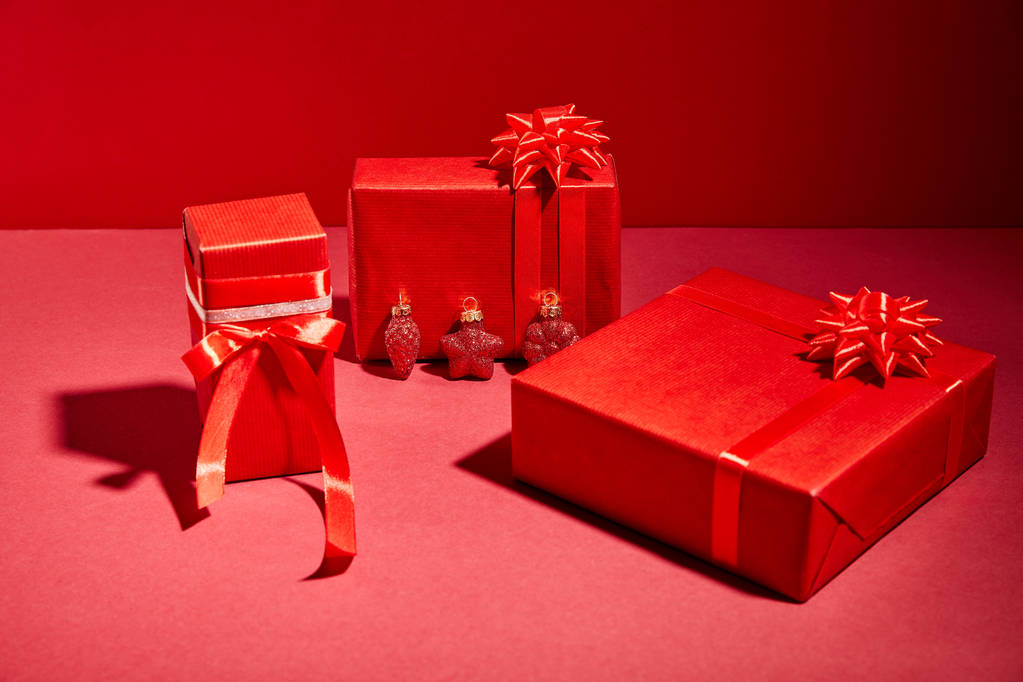scatole regalo festivo avvolto rosso con nastri e fiocchi su sfondo rosso
 - Foto, immagini