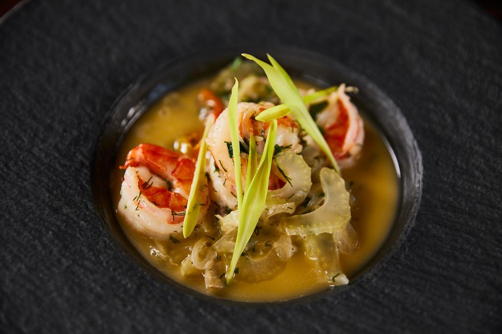 close up view of delicious restaurant soup with shrimps in black plate - Photo, Image