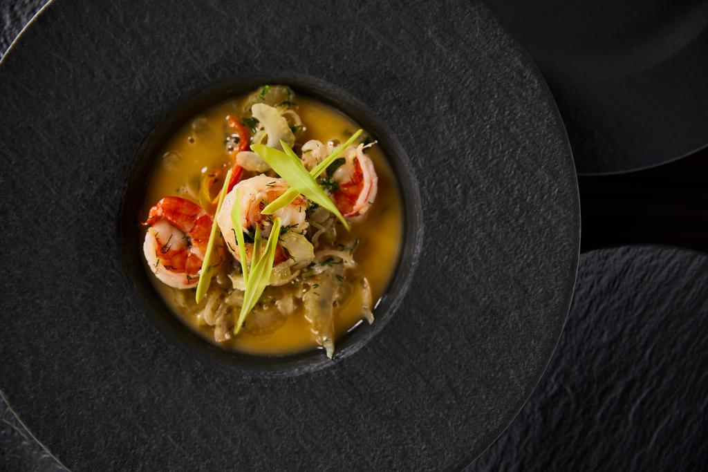 vista dall'alto di deliziosa zuppa ristorante con gamberetti in piatto nero
 - Foto, immagini