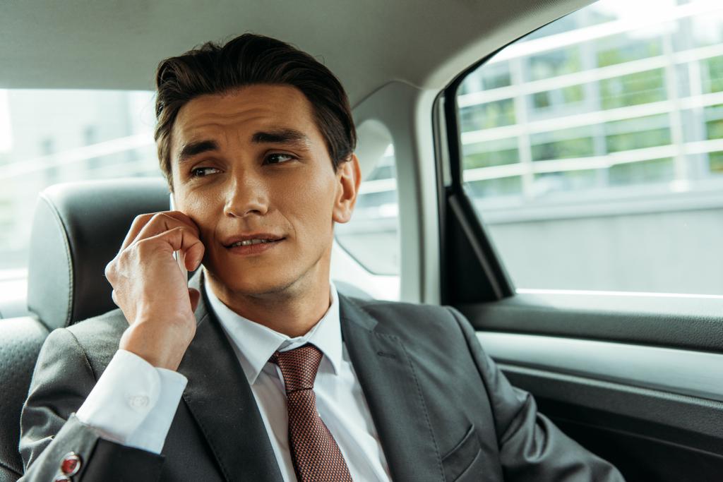 Komea liikemies puhuu älypuhelimella taksissa
 - Valokuva, kuva