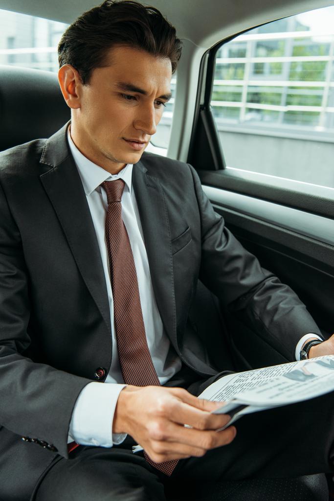 Przystojny biznesmen czyta gazety w taksówce - Zdjęcie, obraz