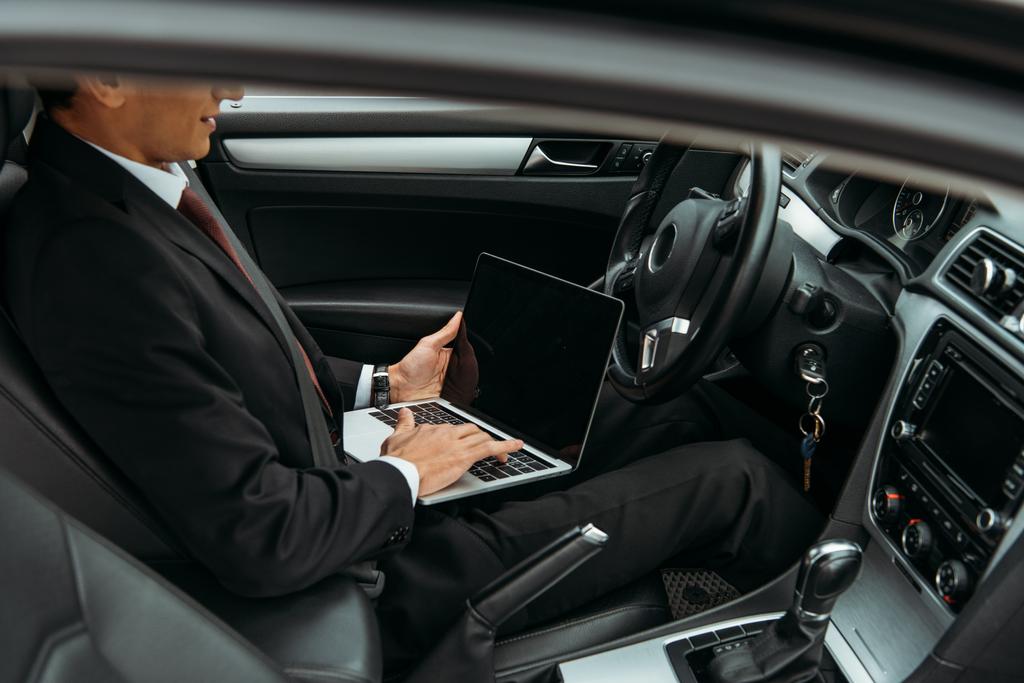 Обрезанный вид бизнесмена с помощью ноутбука в беспилотном автомобиле
 - Фото, изображение