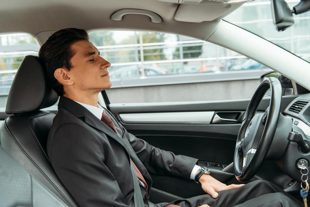 Empresario con los ojos cerrados en el asiento del conductor del coche no tripulado
 - Foto, Imagen