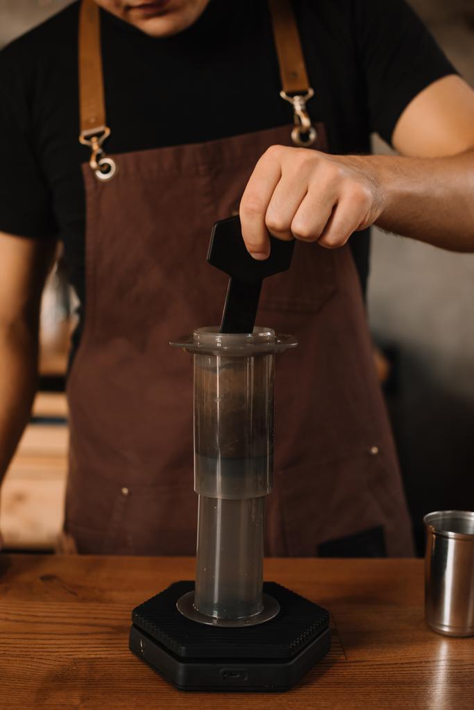 vista recortada de barista preparando café con aeroprensa
 - Foto, Imagen
