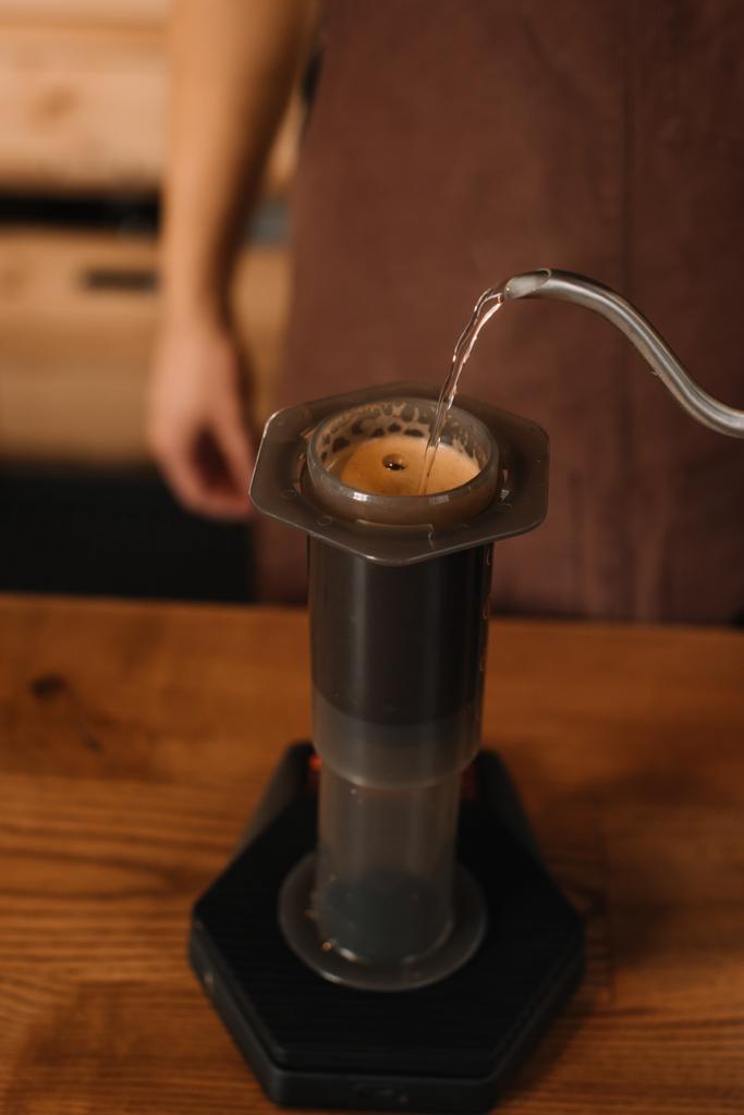 vue recadrée de barista verser de l'eau de la bouilloire dans l'aération tout en préparant le café
 - Photo, image