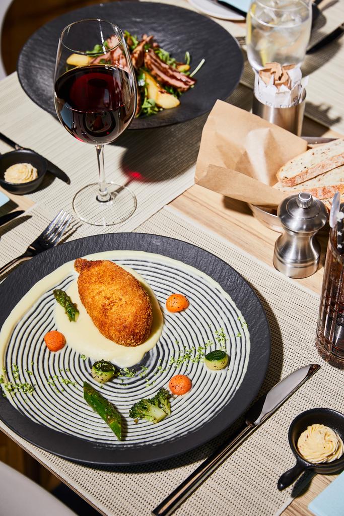 kurczak kiew z tłuczonym ziemniakiem serwowane na stole z napojami w restauracji  - Zdjęcie, obraz