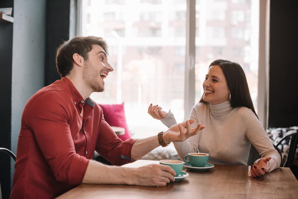 onnellinen nuori pari puhuu kahvilassa
 - Valokuva, kuva