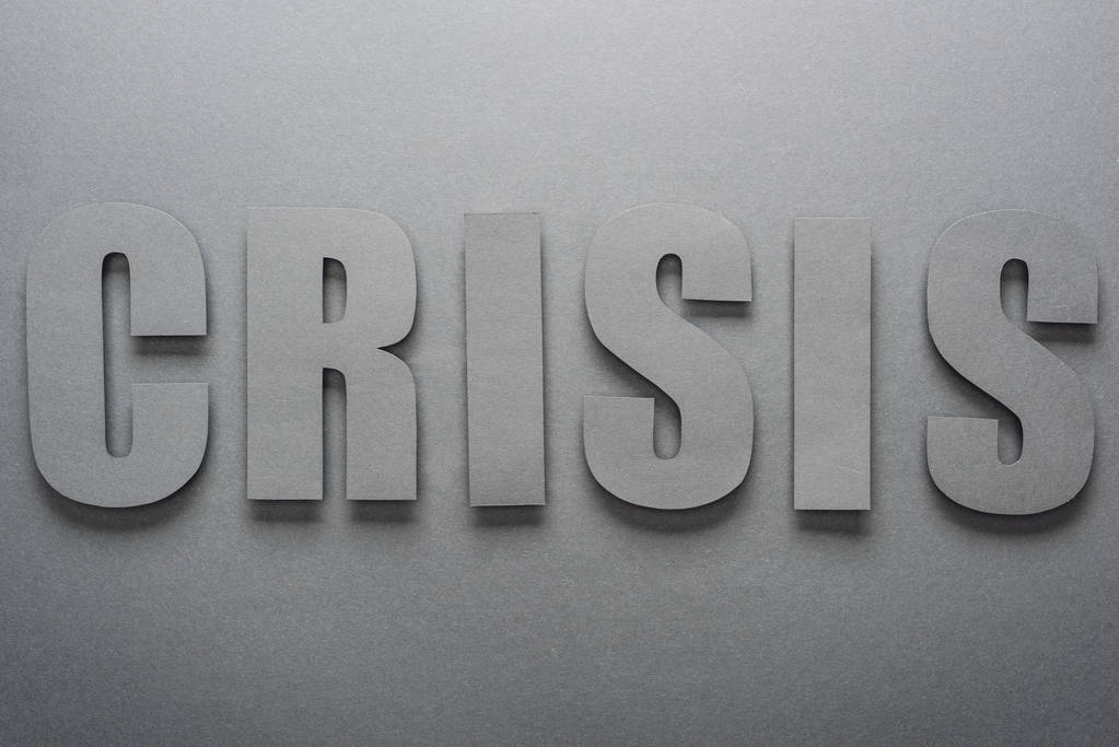 вид зверху паперового вирізаного слова криза на сірому фоні з тінями
 - Фото, зображення