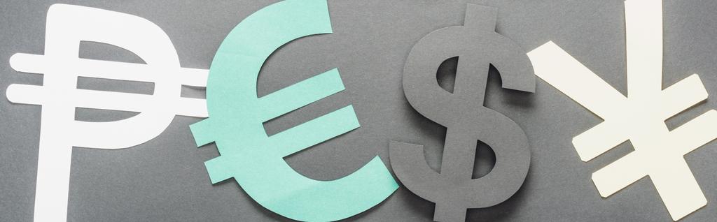 bovenaanzicht van peso, euro, dollar en yen teken op grijze achtergrond, panoramisch beeld - Foto, afbeelding