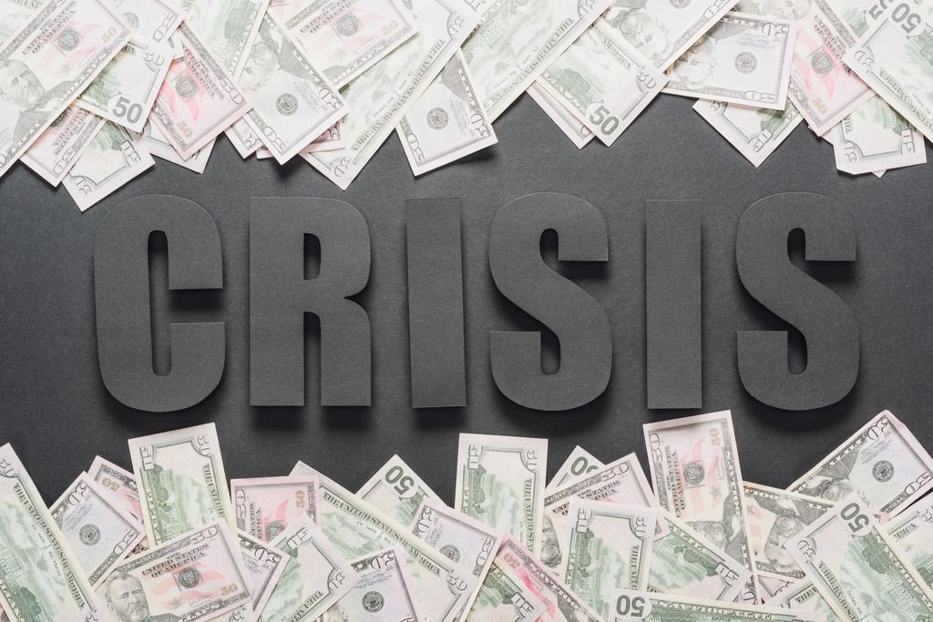 vista superior de la palabra crisis cerca de billetes de dólar dispersos sobre fondo negro con sombras
 - Foto, imagen