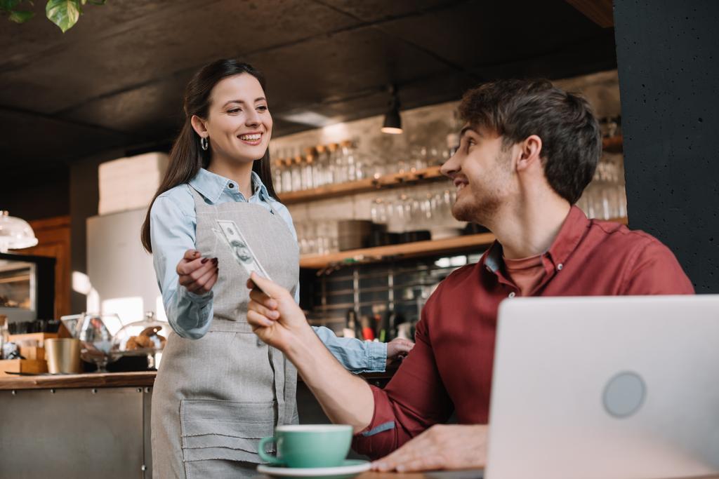 freelancer kanssa kannettava antaa rahaa hymyilevä tarjoilija kahvilassa
 - Valokuva, kuva