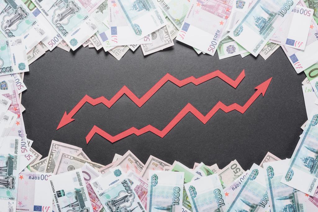 verhoging en recessie pijlen in het kader van dollar, euro en roebel bankbiljetten op zwarte achtergrond - Foto, afbeelding