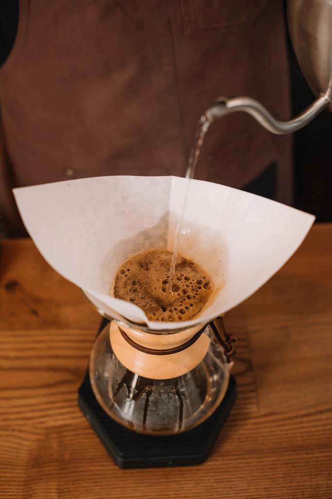 vista parcial de barista preparando café pour-over usando Chemex Coffeemaker
 - Foto, Imagen
