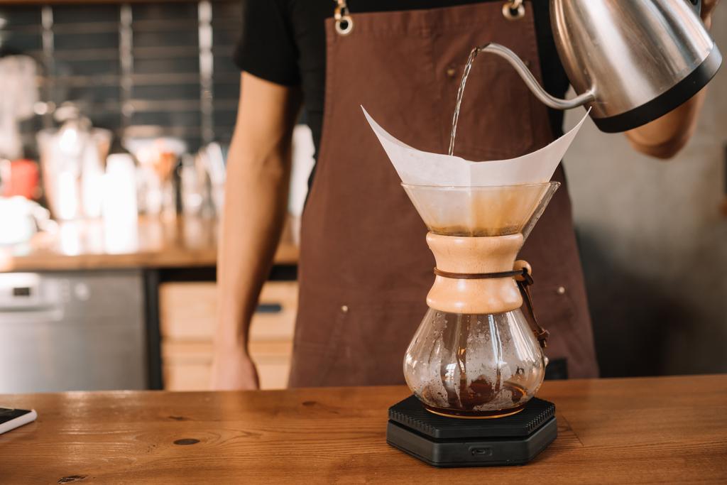 bijgesneden weergave van barista het bereiden van pour-over koffie met behulp van Chemex Coffeemaker - Foto, afbeelding