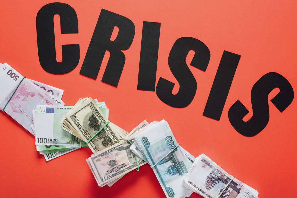 vista superior del papel negro cortar la crisis palabra en dólares, euros y billetes de rublo sobre fondo rojo
 - Foto, Imagen