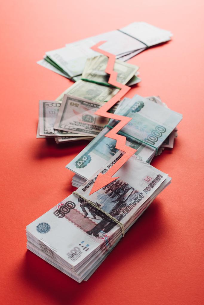 вибірковий фокус стрілки рецесії паперу на рублі, доларах та євро банкнотах на червоному тлі
 - Фото, зображення