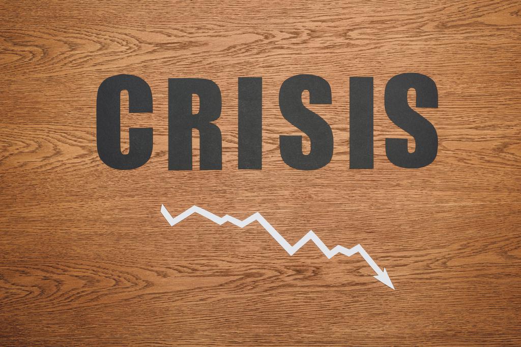 вид зверху чорний папір вирізав слово "криза" і "стрілка рецесії" на дерев'яному столі
 - Фото, зображення