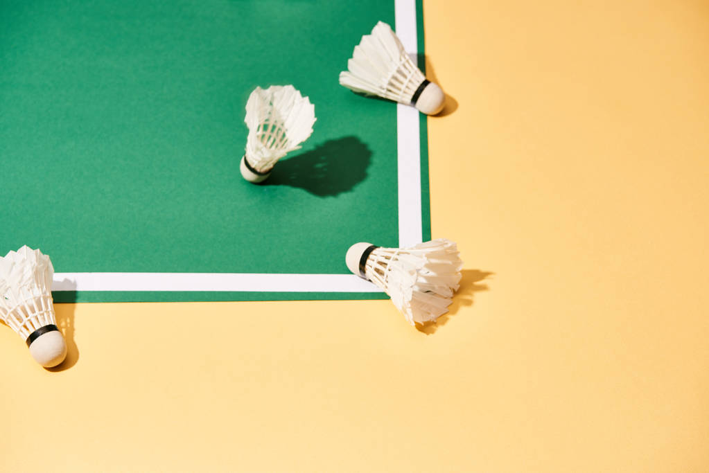 Badminton shuttlecocks na quadra verde e superfície amarela
 - Foto, Imagem