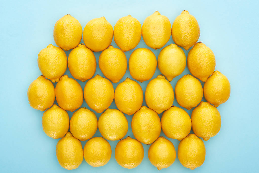 vue du dessus des citrons jaunes mûrs sur fond bleu - Photo, image