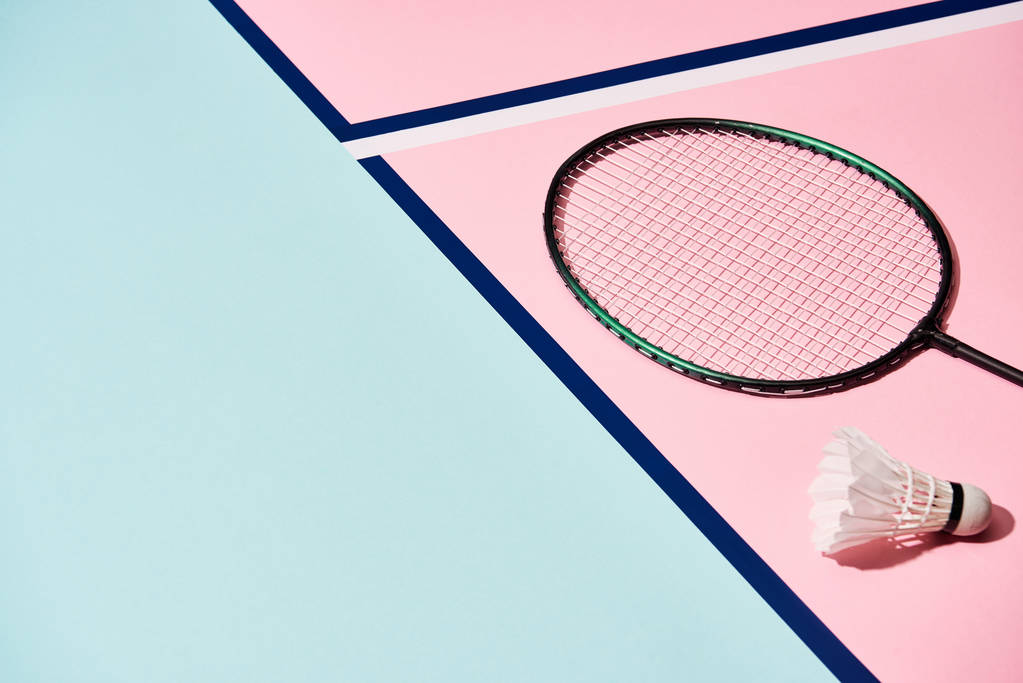Badminton ρακέτα και shuttlecock σε πολύχρωμη επιφάνεια με μπλε γραμμές - Φωτογραφία, εικόνα