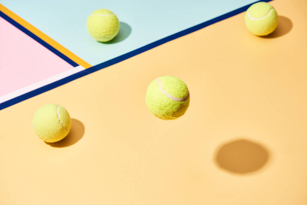 Vista de ángulo alto de pelotas de tenis con sombra sobre fondo colorido con líneas azules
 - Foto, Imagen