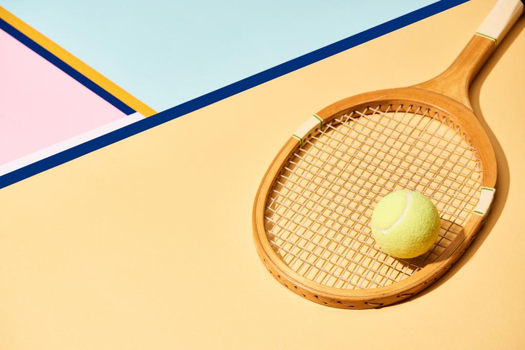 Pelota de tenis amarilla sobre raqueta de madera sobre fondo con líneas azules
 - Foto, imagen