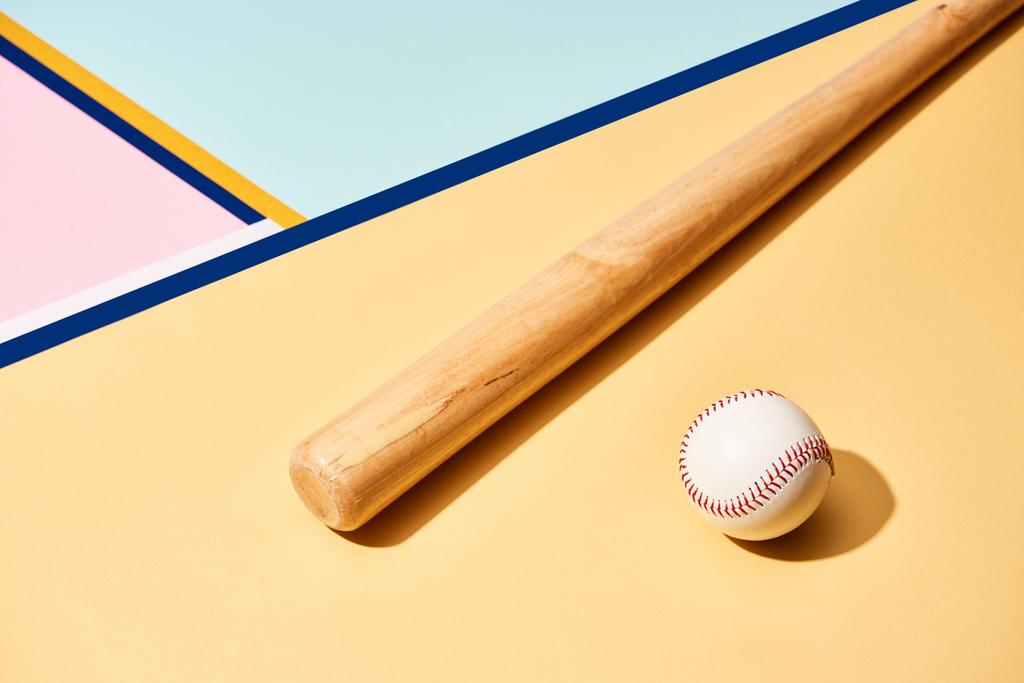 Bate y pelota de béisbol de madera sobre fondo colorido con líneas
 - Foto, Imagen