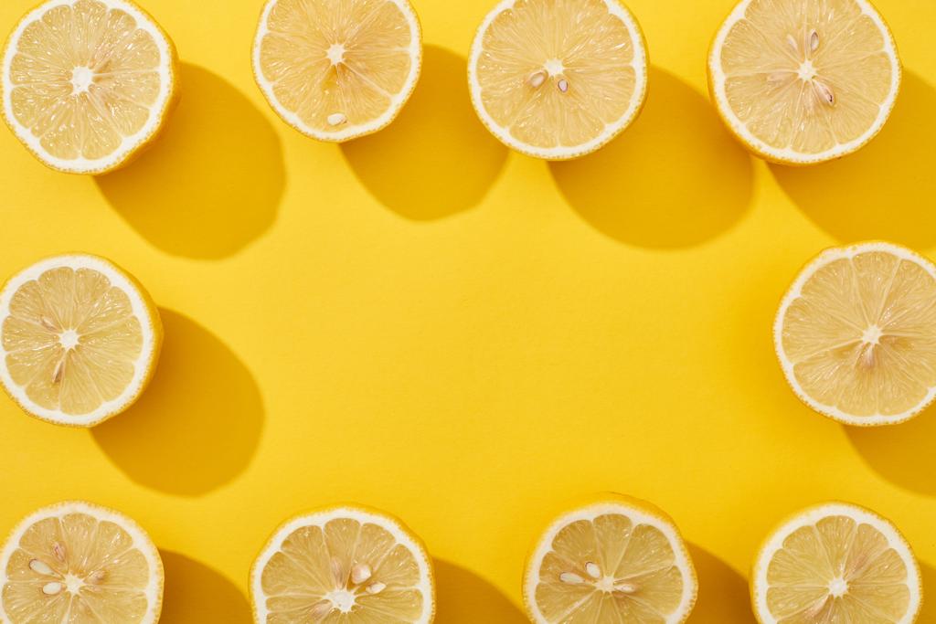 horní pohled na zralé řezané citrony uspořádané ve čtvercovém rámečku na žlutém pozadí s kopírovacím prostorem - Fotografie, Obrázek
