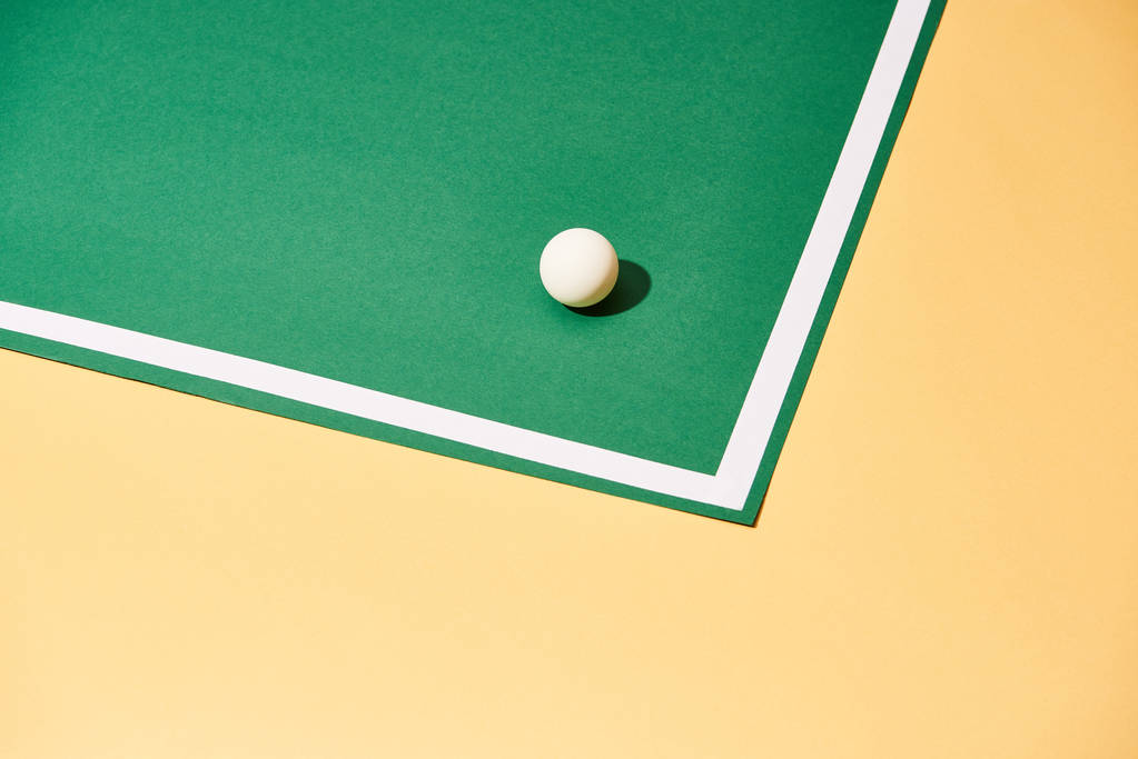 Настольный теннисный мяч с тенью на зеленом и желтом фоне
 - Фото, изображение