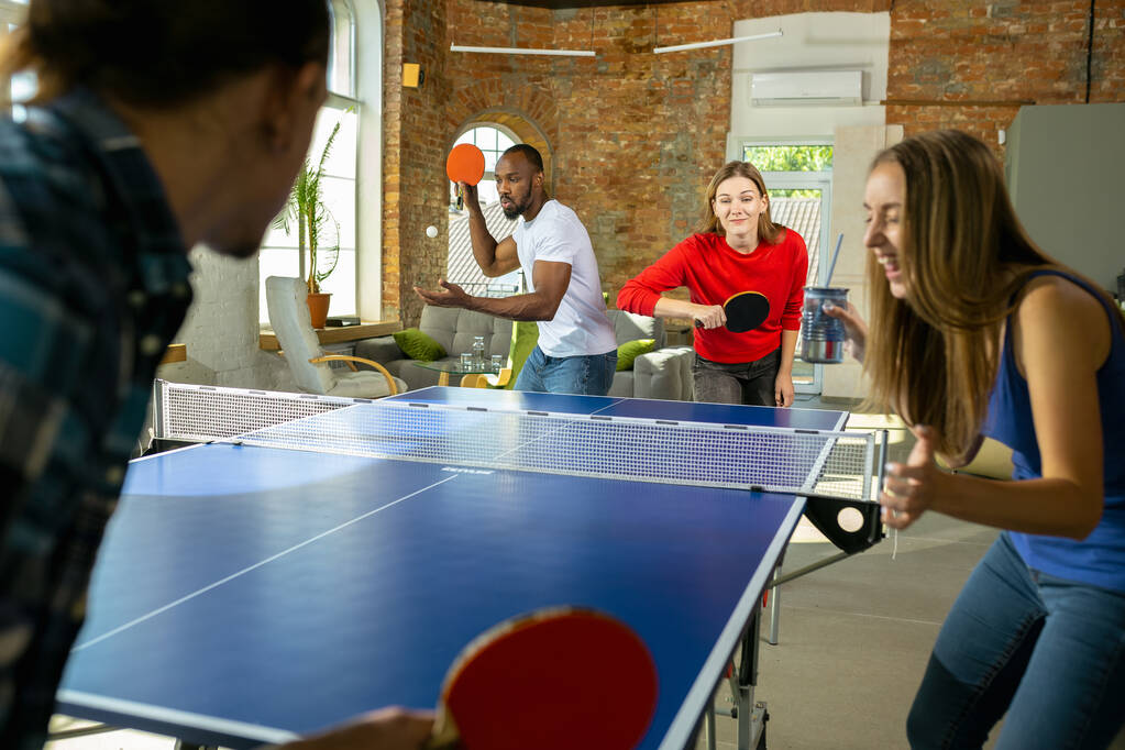 Jugendliche spielen Tischtennis am Arbeitsplatz und haben Spaß - Foto, Bild