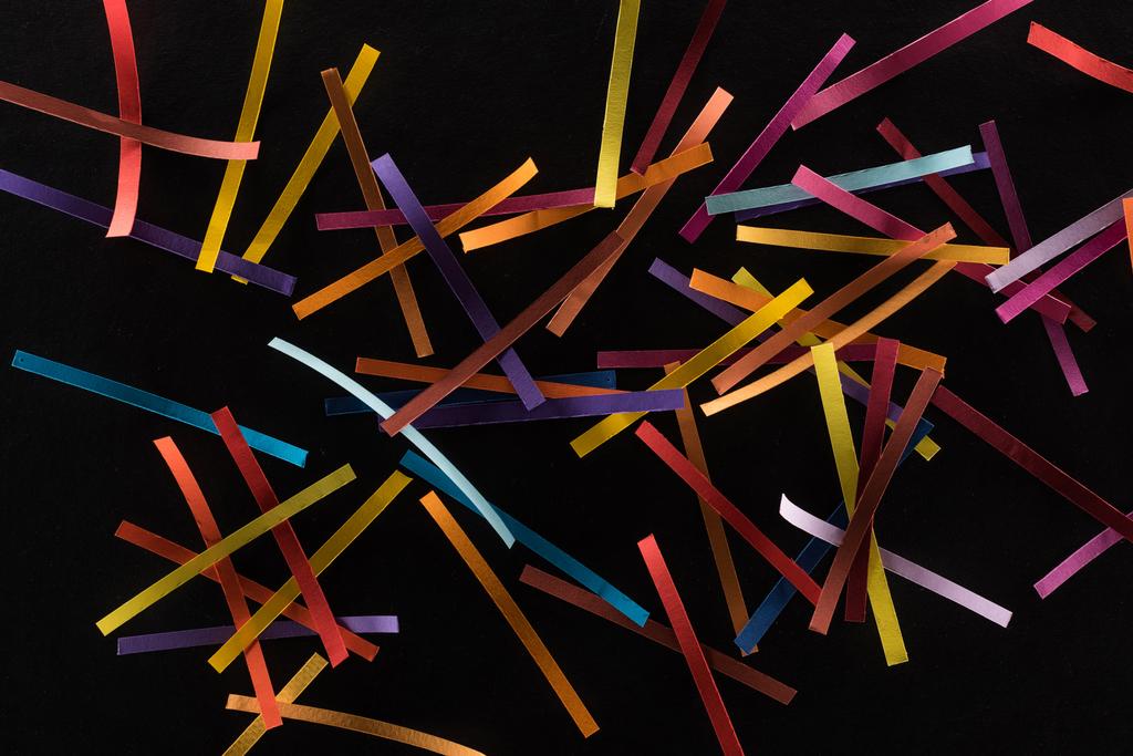 vue de dessus de lignes abstraites multicolores dispersées isolées sur fond noir, concept de connexion et de communication
 - Photo, image