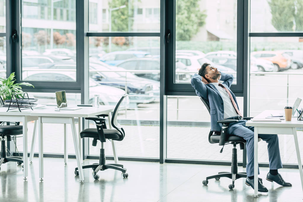 mladý podnikatel odpočívá na pracovišti v moderní prostorné kanceláři - Fotografie, Obrázek