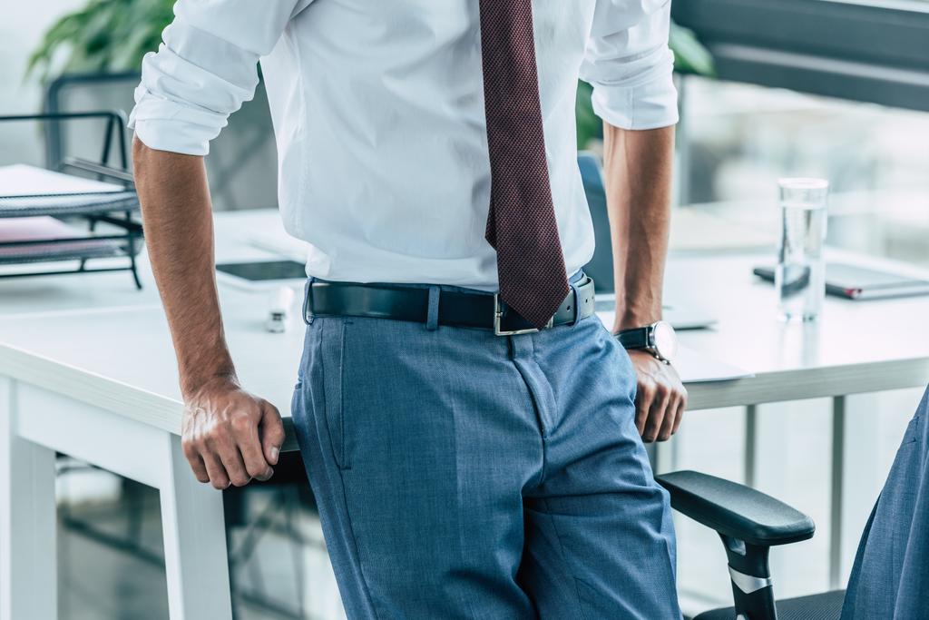cropped view of businessman standing near workplace in office - Photo, Image