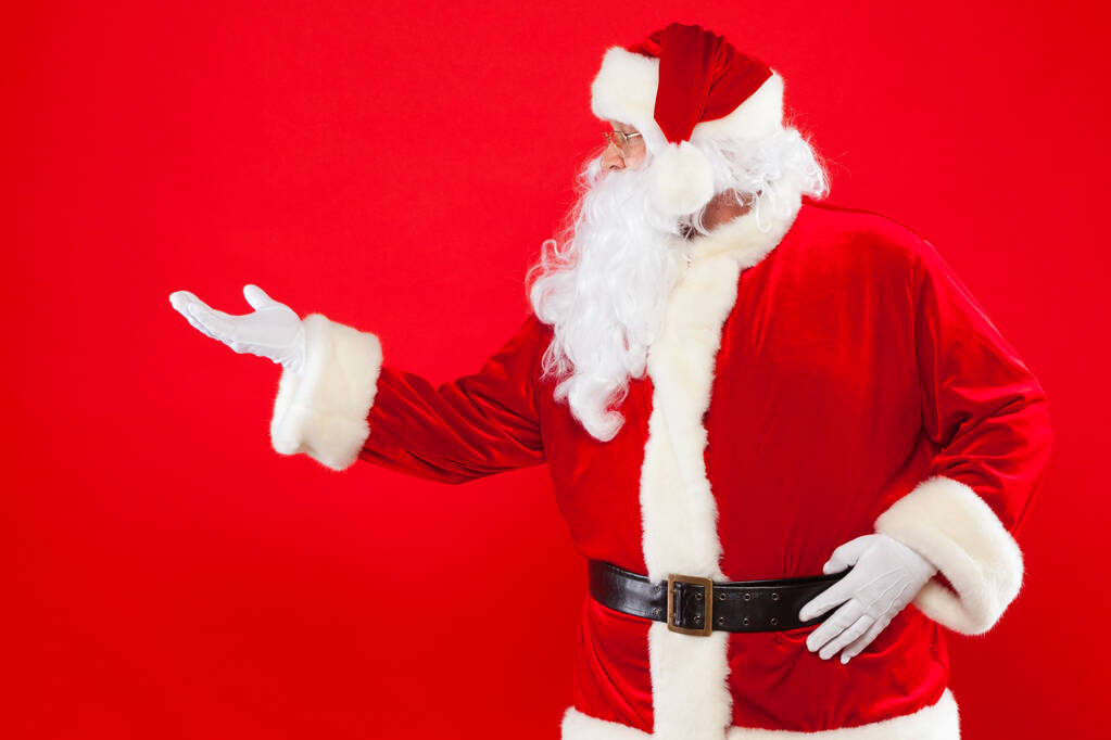 Santa Claus señalando en blanco un lugar, fondo rojo
 - Foto, Imagen