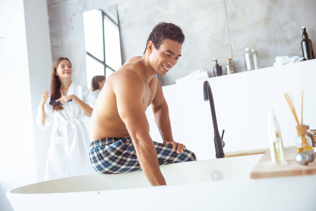 Joyful international man preparing bath for washing - Fotografie, Obrázek