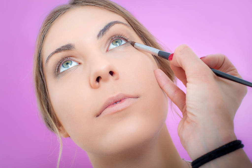 Makeup professional artist applying base color eyeshadow on mode - Photo, Image