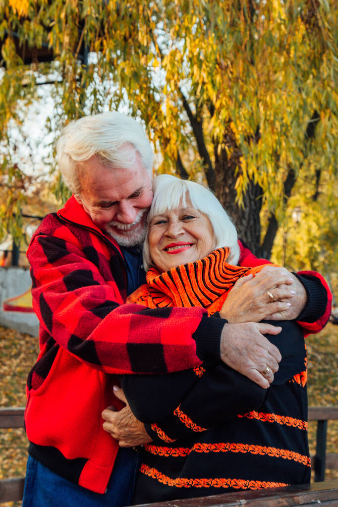 Boldog nyugdíjas pár élvezik egymást a parkban. Támogatás és törődés egy szerettünktől, meleg érzelmek. - Fotó, kép