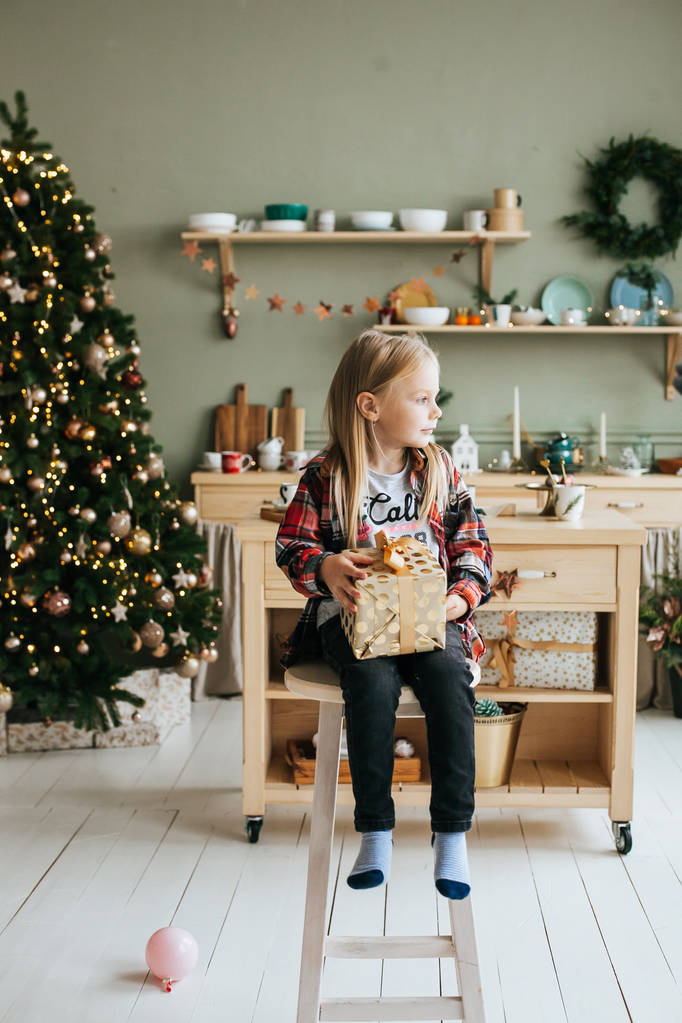 Cute little girl with christmas present at home - 写真・画像