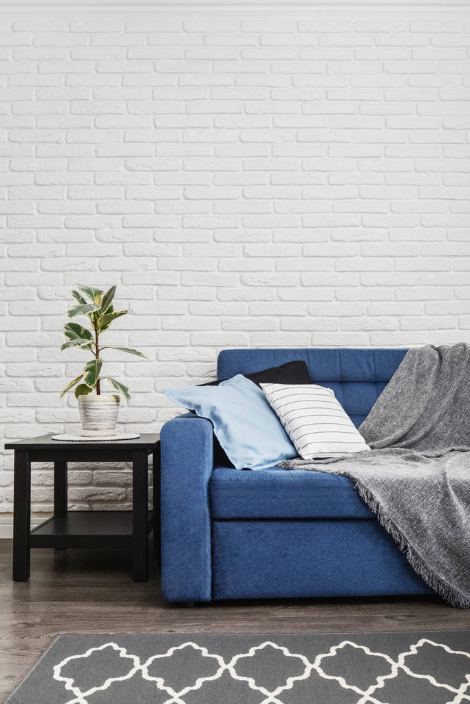 Canapé bleu avec oreillers et plaid gris
 - Photo, image