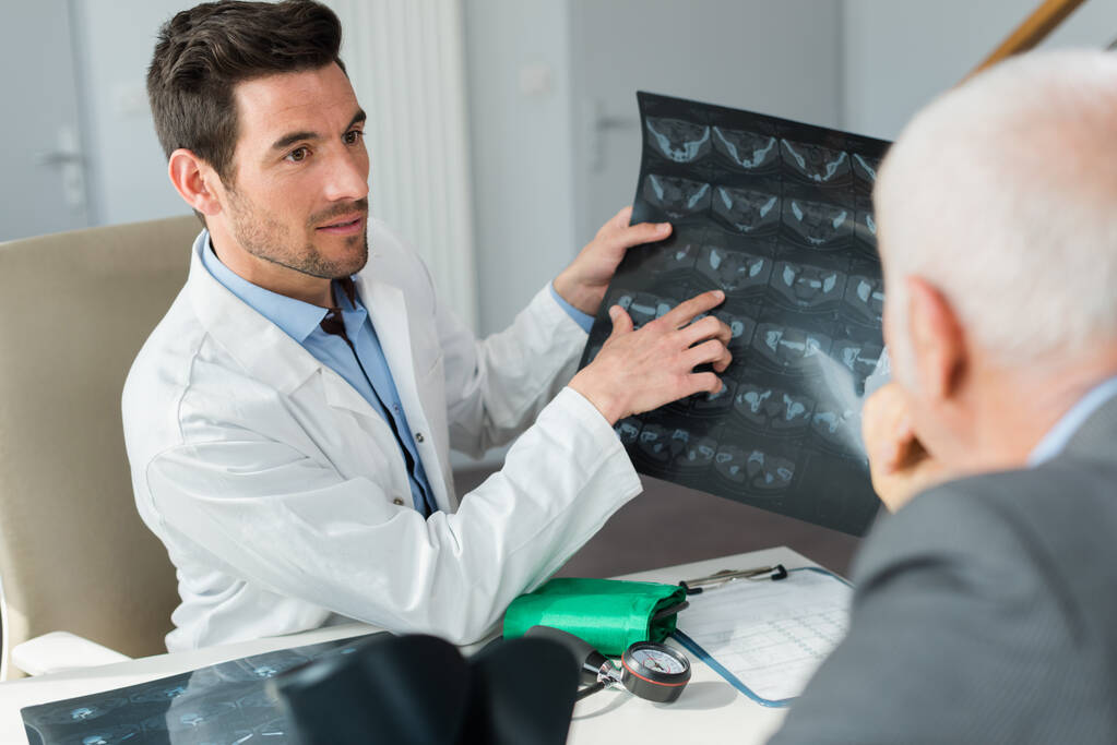 Porträt des Arztes zeigt Patient Röntgen - Foto, Bild