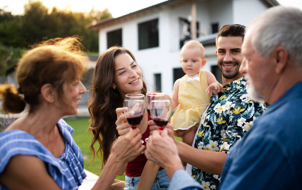 Muotokuva ihmisistä, joilla on viiniä ulkona perheen puutarhassa grilli
. - Valokuva, kuva