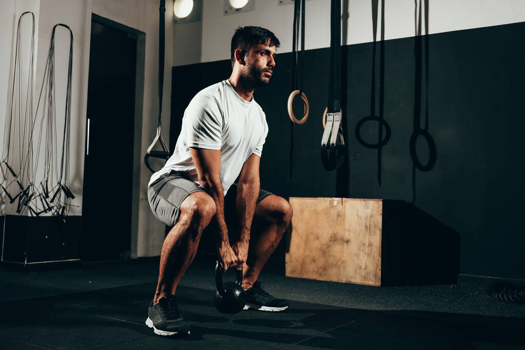 Man working out with a kettlebell in a gym - Photo, Image