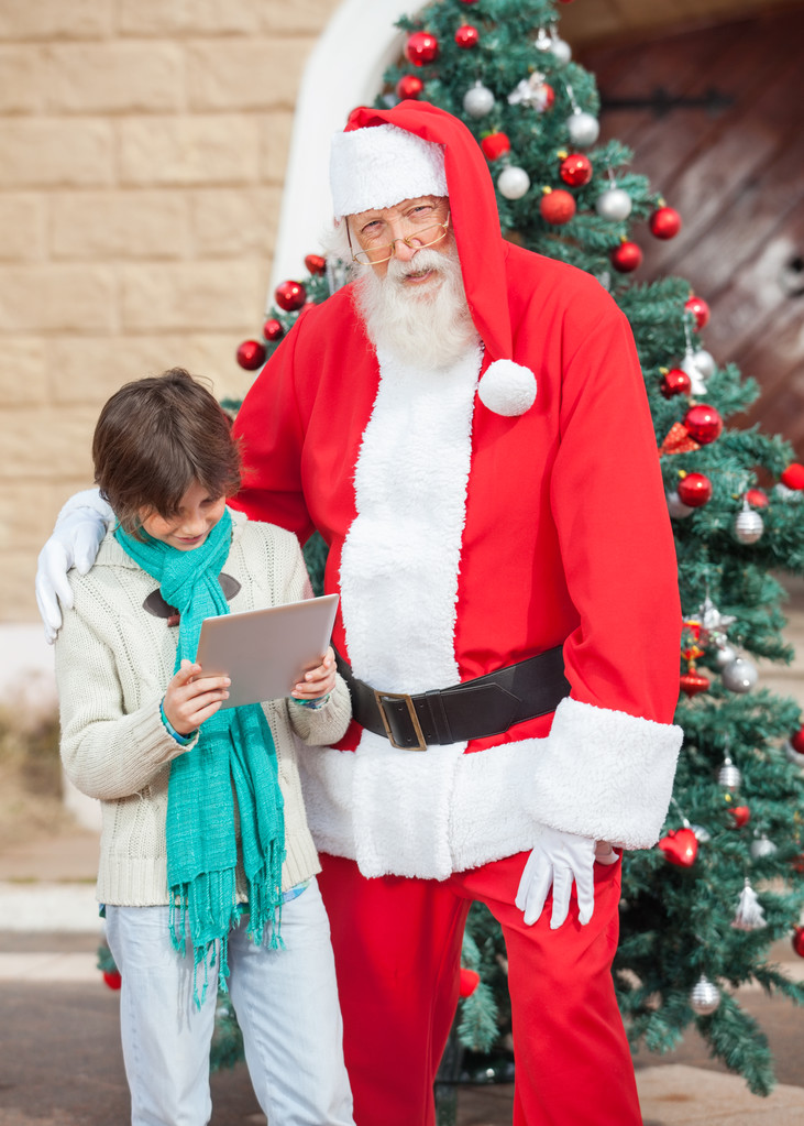 Noel Baba ayakta dijital tablet kullanarak çocuk ile - Fotoğraf, Görsel