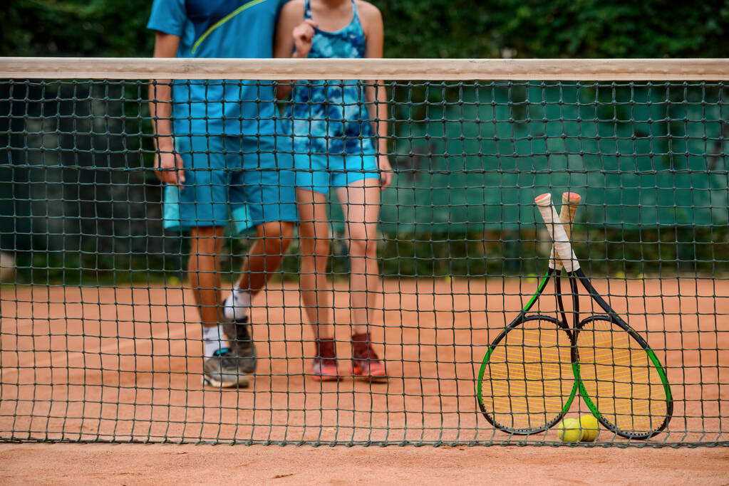 Baja tiro de los atletas que se acercan a la red para tomar sus raquetas y bolas
. - Foto, imagen