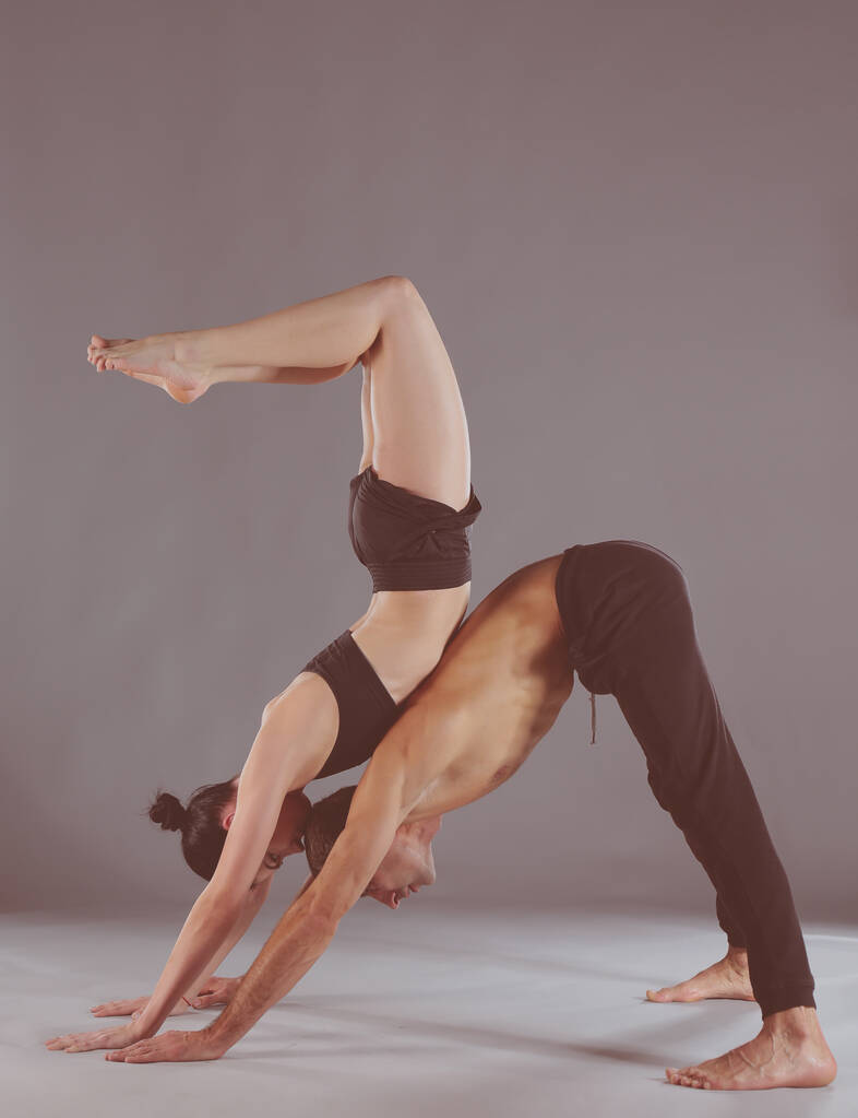 Jong koppel acro yoga beoefenen op mat samen in de studio. Acroyoga. Paar yoga. Partner yoga. - Foto, afbeelding