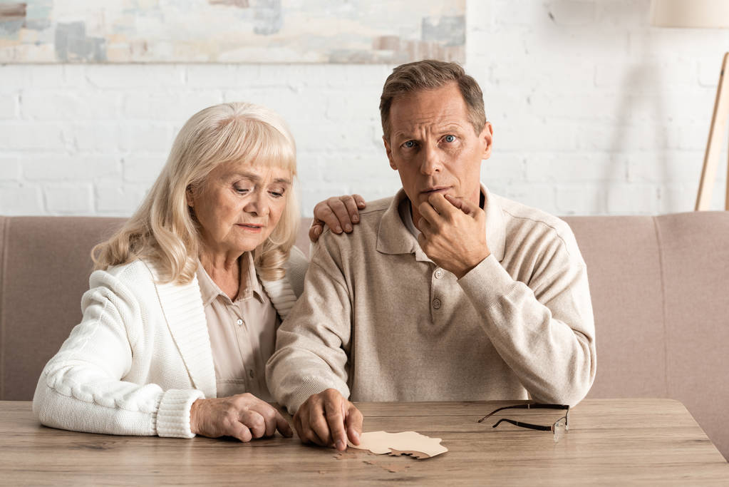 ηλικιωμένος άνδρας με νόσο Αλτσχάιμερ κάθεται κοντά σε θλιμμένη σύζυγο  - Φωτογραφία, εικόνα