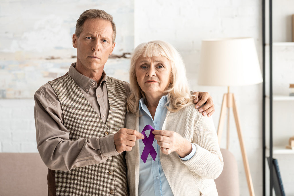 пожилая пара стоит и держит фиолетовую ленту
  - Фото, изображение
