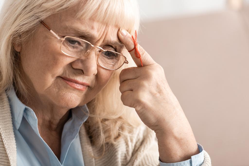 töprengő idős nő Alzheimers betegség string emberi ujj emlékeztető  - Fotó, kép
