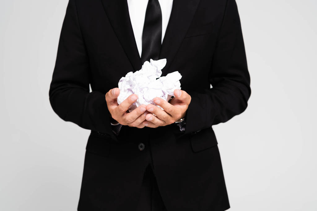 vue recadrée d'un homme d'affaires en costume tenant des papiers froissés isolés sur du gris
 - Photo, image